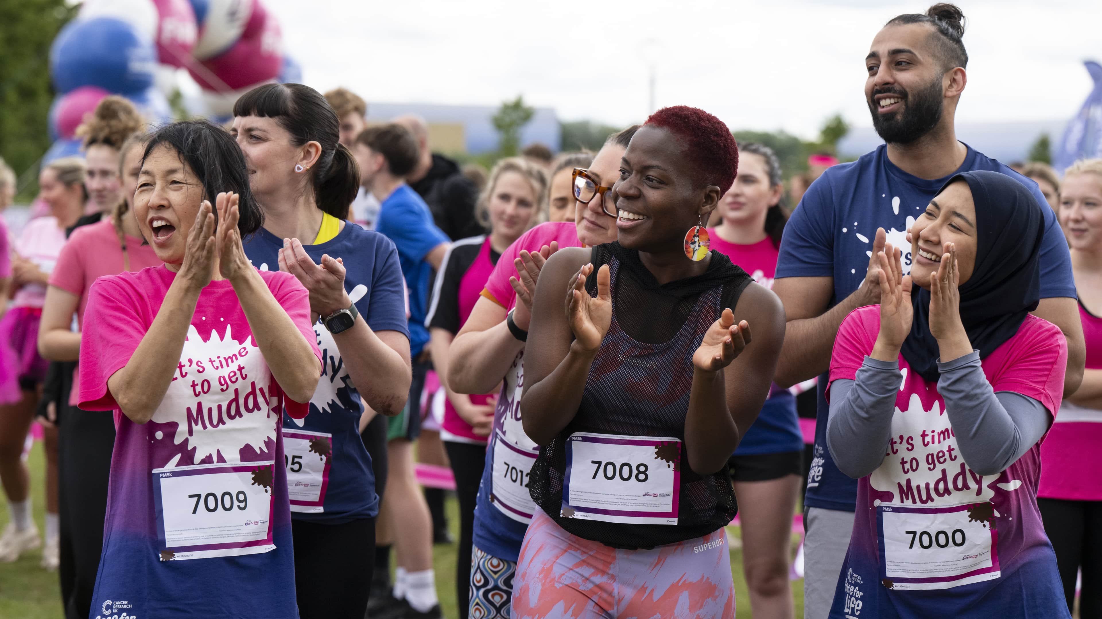 A group of participants  cheering and clapping in the crowd at Race for Life.